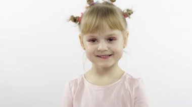 Olumlu kız duygusal olarak yüzler yapar ve pembe bluz içinde gülümser. Beyaz arkaplan
