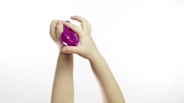 Des mains d'enfant jouant bizarrement de la boue violette sur fond blanc. Antistress — Video