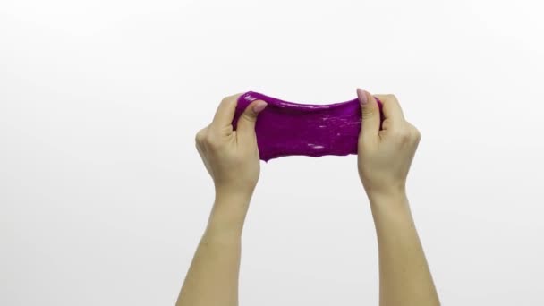 Vrouw speelt vreemd genoeg paars slijm. Witte achtergrond. Antistress — Stockvideo