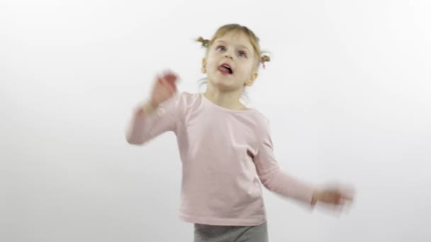 Positief meisje in roze blouse dansen. Gelukkige vier kleine kinderen. Witte achtergrond — Stockvideo