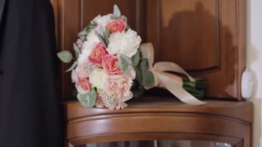 Ahşap gardıropta güzel bir düğün buketi. Pembe, beyaz çiçekli buket