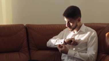 Yakışıklı damat adam kol düğmeleri ile bir ceket onun manşet düzeltir. Işadamı