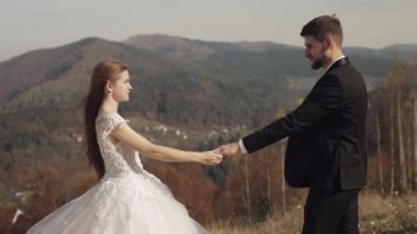 Yeni evliler. Dağın yamacında gelinle birlikte beyaz bir damat. Düğün çifti. Mutlu