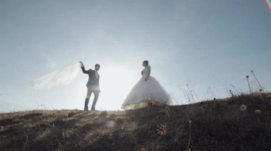 Yeni evliler. Dağın yamacında gelinle birlikte beyaz bir damat. Düğün çifti. Mutlu