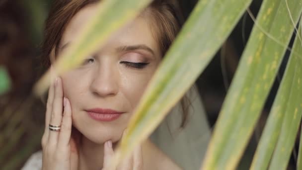 Face of beautiful and lovely bride in wedding dress in the park. Slow motion — Stock Video