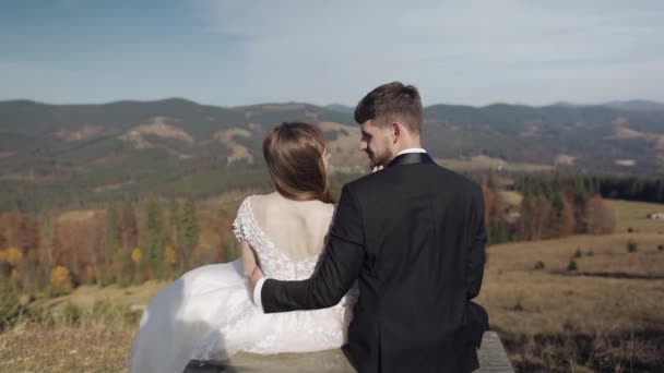 Friss házasok. Fehér vőlegény menyasszonnyal a lejtőn. Esküvői pár. Boldog. — Stock videók