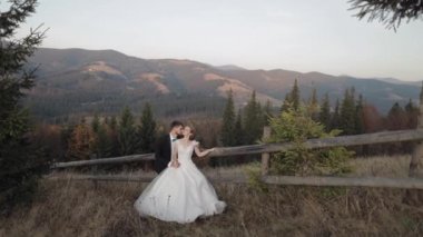 Yeni evliler. Dağın yamacında gelinle birlikte beyaz bir damat. Düğün çifti. Mutlu
