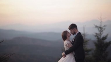 Yeni evliler. Dağın yamacında gelinle birlikte beyaz bir damat. Düğün çifti. Mutlu