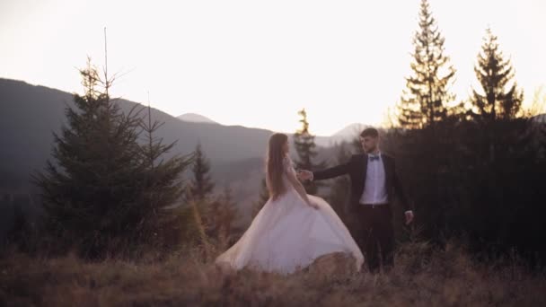 Frisch verheiratet. Kaukasischer Bräutigam mit Braut, die am Berghang tanzt. Hochzeitspaar — Stockvideo
