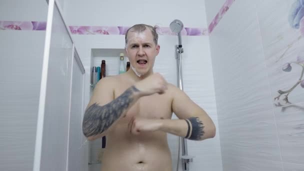 Junge hübsche dicke Mann nimmt eine Dusche im Badezimmer. Emotional singt und tanzt — Stockvideo