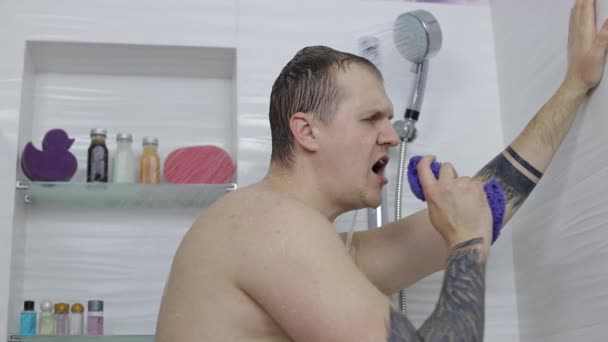 Jóképű izmos férfi zuhanyozik a fürdőszobában. Érzelmileg énekel, táncol — Stock videók