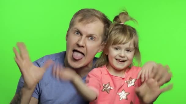 Батько і маленька донька роблять обличчя до камери. Кром-ключ. День батьків — стокове відео