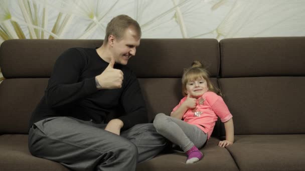 Padre e hija riendo, jugando juntos en el sofá. Ocio juego — Vídeos de Stock