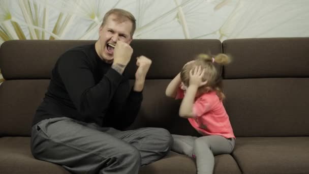 Apa és a kislánya kő-papír ollót játszanak a kanapén. Szabadidős játék — Stock videók