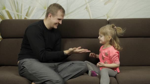 Vader en dochtertje lachen, spelen samen op de bank. Vrijetijdsspel — Stockvideo