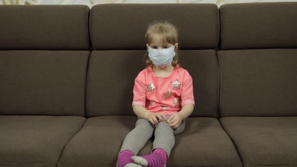 Concept of sick little girl wearing a medical mask. Quarantine. Coronavirus — Stock Video