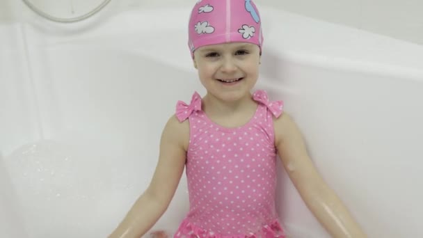 Cute blonde girl takes a bath in swimwear. Little child, 4 years old. Hygiene — Stock Video