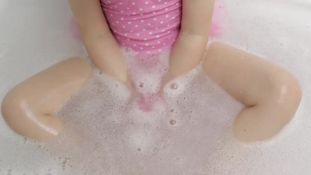 Hands of girl puts bath bomb to water. Ball of bath salt dissolves in water — Stock Video