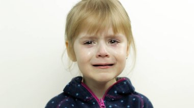 Gözlerinde yaşlarla ağlayan küçük bir kızın portresi. Beyaz arkaplan