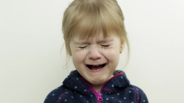 Portrét malé holčičky, jak pláče a slzy jí stékají po tváři. Bílé pozadí — Stock video