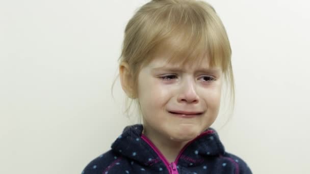 Retrato de una niña llorando con lágrimas en la cara. Fondo blanco — Vídeos de Stock