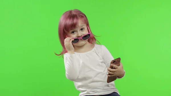 Akıllı telefon kullanan bir kız. Çocuk cep telefonuyla duygusal konuşuyor, selfie çekin. — Stok fotoğraf