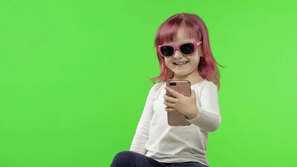Menina usando smartphone. Criança emocionalmente falando no celular, tire selfie — Fotografia de Stock