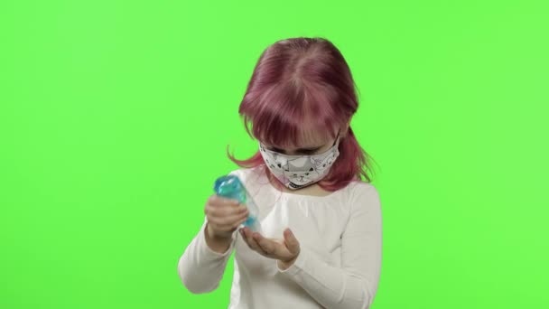 Маленькая девочка в медицинской маске. Использует антисептик для рук. Коронавирус COVID-19 — стоковое видео