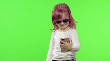 Akıllı telefon kullanan bir kız. Çocuk cep telefonuyla duygusal konuşuyor, selfie çekin.