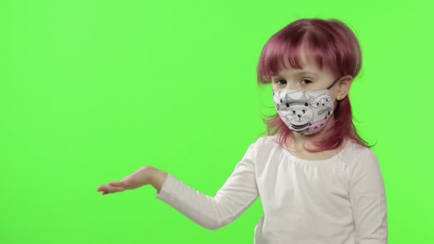Mała dziewczynka coś pokazuje. Maska medyczna. Pandemiczny COVID-19 koronawirus — Wideo stockowe