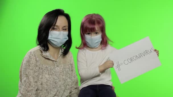 Nemocná matka a dcera v masce ukázat stránku se zprávou. Koncept koronaviru — Stock video