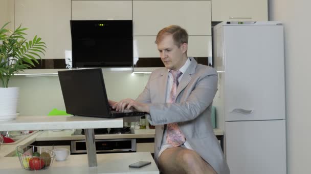 Бизнесмен в галстуке и куртке работает над ноутбуком в домашнем офисе. Удаленная работа — стоковое видео
