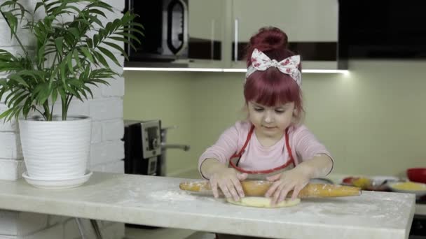 Cocinar pizza. Pequeño niño en delantal rollo de masa con rodillo en casa cocina — Vídeos de Stock