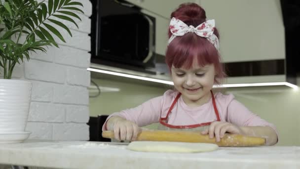 Готовлю пиццу. Маленький ребенок в фартуке тесто с булавкой на домашней кухне — стоковое видео