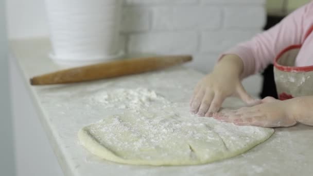 Vařím pizzu. Malé dítě v zástěře připravuje těsto na vaření v kuchyni — Stock video