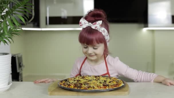 Pizza pişiriyorum. Mutfakta taze pişmiş pizzayla önlüklü küçük çocuk. — Stok video