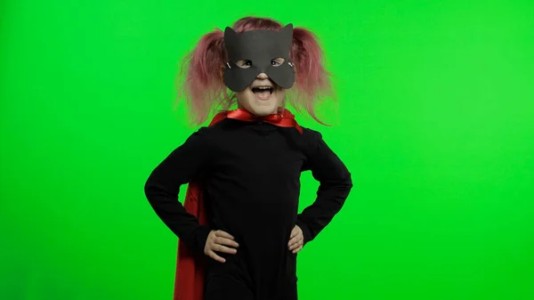 Забавна дівчинка в костюмах і масках грає супергероя. Національний день супергероя — стокове фото