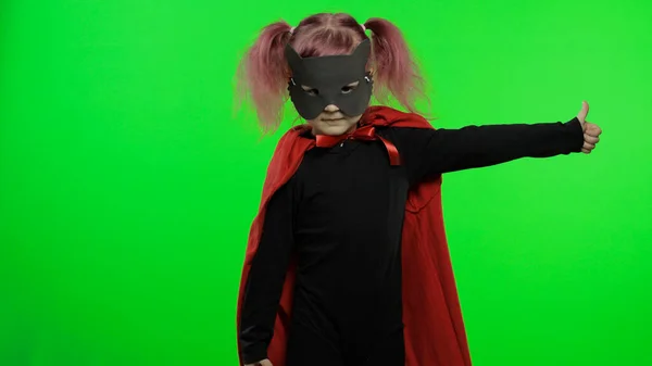 Zabawna dziewczynka w kostiumie i masce gra superbohatera. Narodowy Dzień Superbohatera — Zdjęcie stockowe