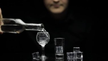 Barmen şişeden dondurulmuş votkayı buzlu iki bardağa döktü. Siyah arkaplan