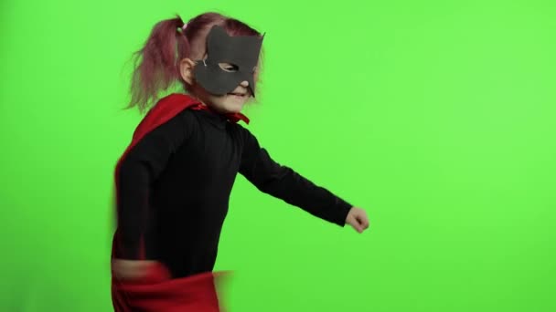 Funny child girl in costume and mask plays super hero. National superhero day — Stock Video