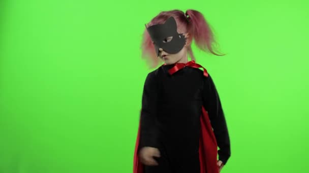 Menina engraçada em traje e máscara joga super herói. Dia nacional do super-herói — Vídeo de Stock