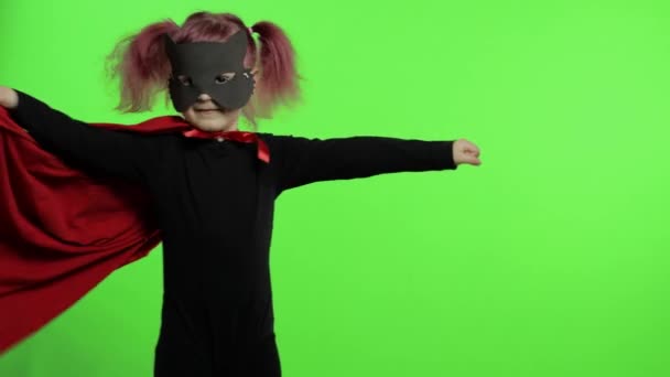 Funny niña en traje y máscara juega super héroe. Día nacional del superhéroe — Vídeos de Stock