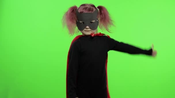 Lustiges Kindermädchen in Kostüm und Maske spielt Superheldin. Nationaler Superheldentag — Stockvideo