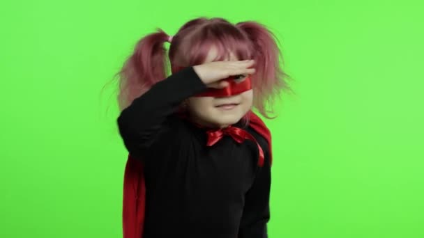 Grappig kind meisje in kostuum en masker speelt super held. Nationale superheldendag — Stockvideo
