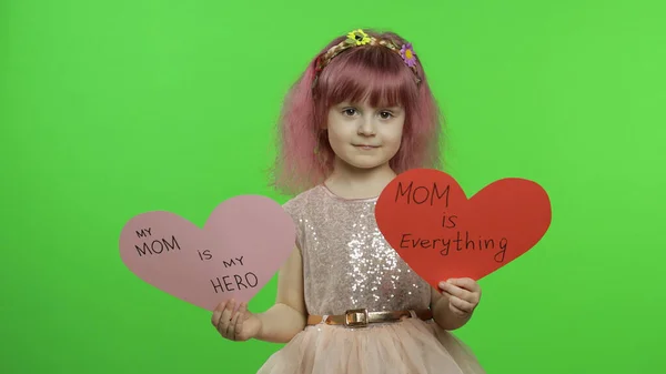 Criança princesa menina detém dois corações de papel com texto sobre a mãe. Dia das mães — Fotografia de Stock