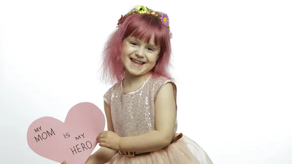 Barnflicka prinsessa håller rosa papper hjärta med text om mor. Mödradagen — Stockfoto
