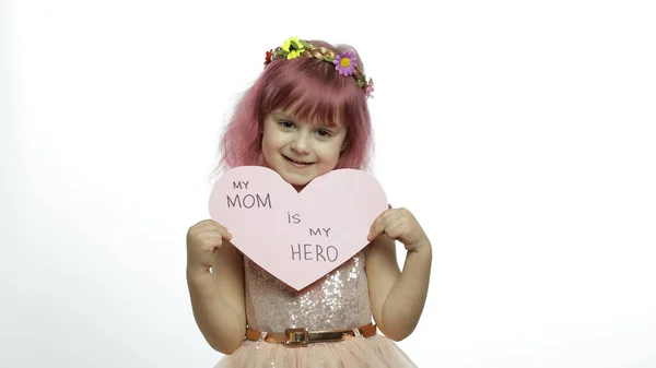 Девочка принцесса держит розовое бумажное сердце с текстом о матери. День матери — стоковое фото