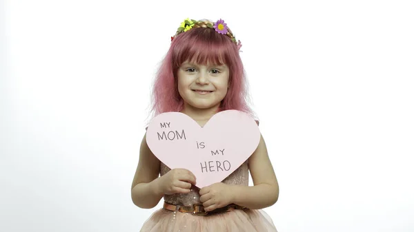 Девочка принцесса держит розовое бумажное сердце с текстом о матери. День матери — стоковое фото
