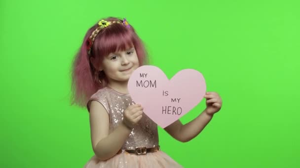 La principessa bambina tiene il cuore di carta rosa con testo su madre. Festa della mamma — Video Stock