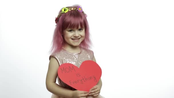 Девочка-принцесса держит красное бумажное сердце с текстом о матери. День матери — стоковое видео